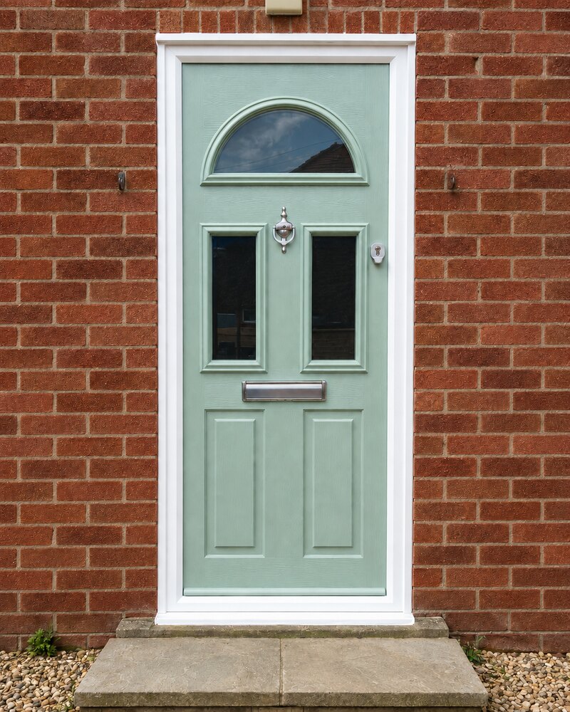 Sage green composite front door with arched top light on a Lincolnshire home