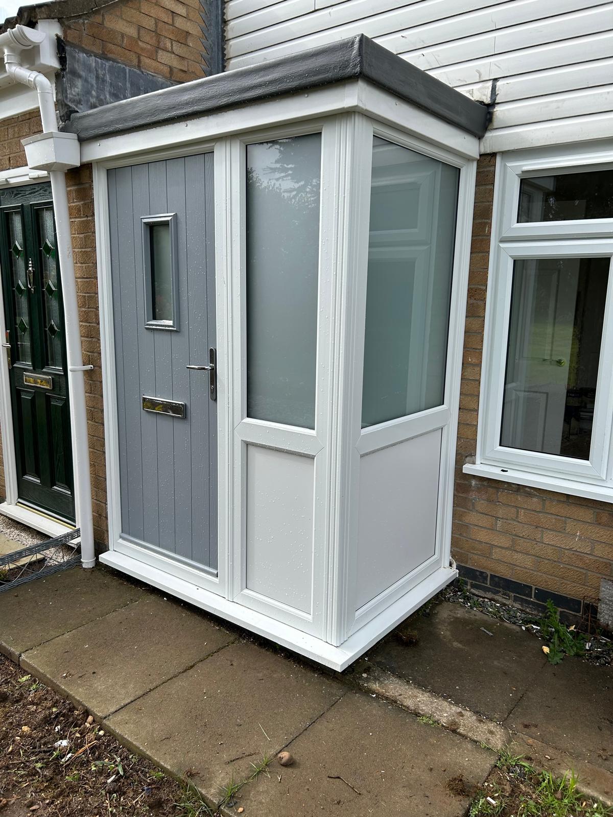 White UPVC porch enclosure with a grey composite door and obscure glazed panels built onto a brick house in Lincolnshire