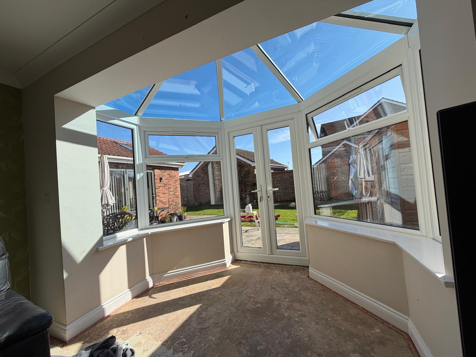 Interior of a white UPVC conservatory with glass roof and French doors in South Lincolnshire