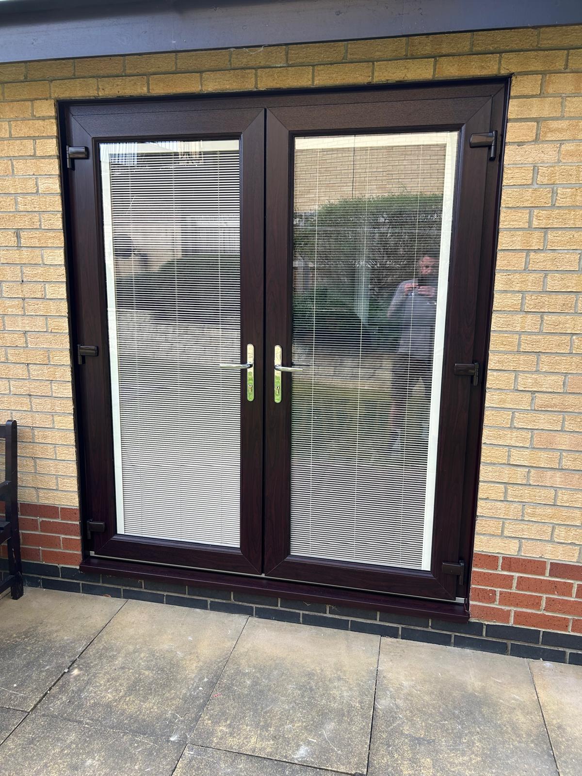 Rosewood woodgrain UPVC French doors with integral blinds fitted to a brick bungalow in Peterborough
