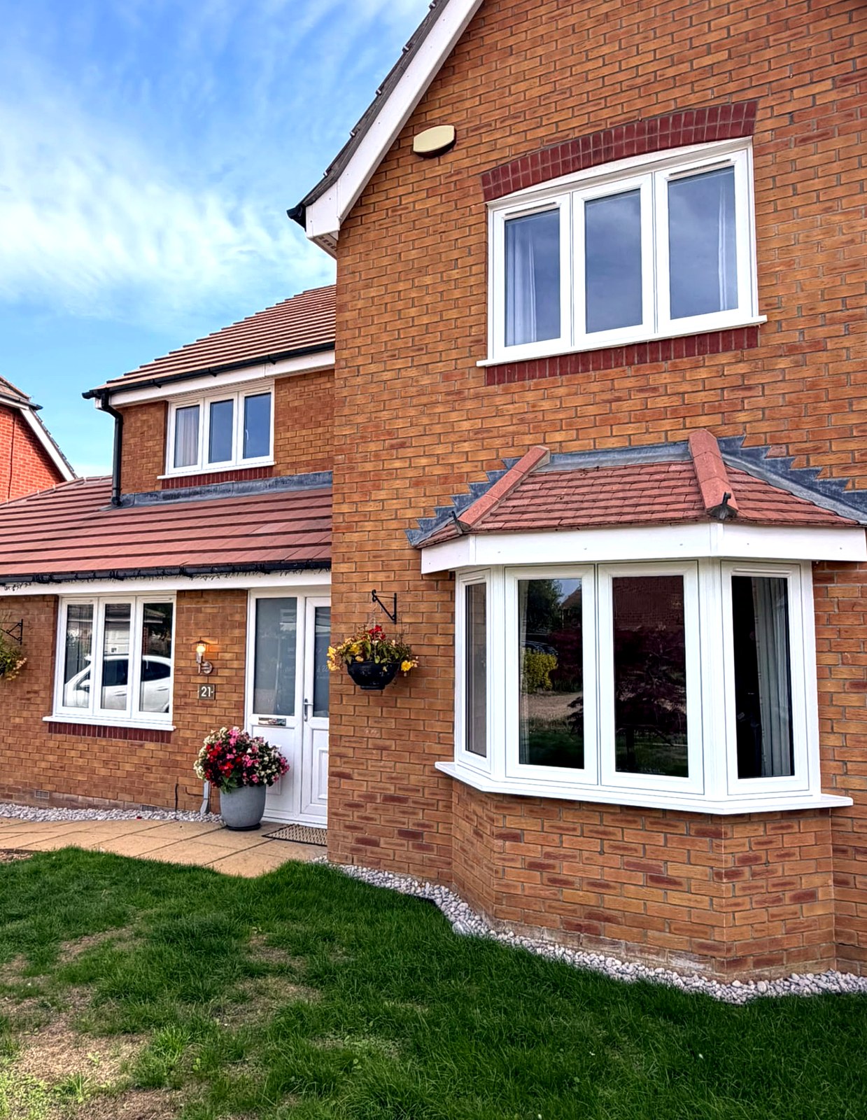 White flush casement windows fitted across the front elevation of a red brick home in Langtoft