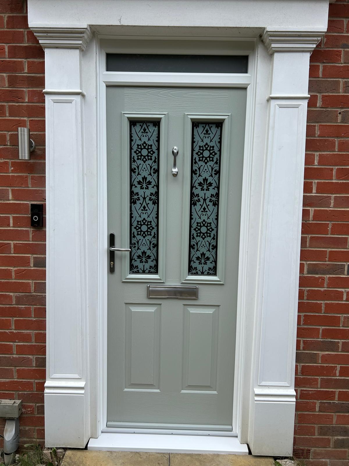 Chartwell green composite front door with etched decorative glazed panels under a stone canopy in Stamford