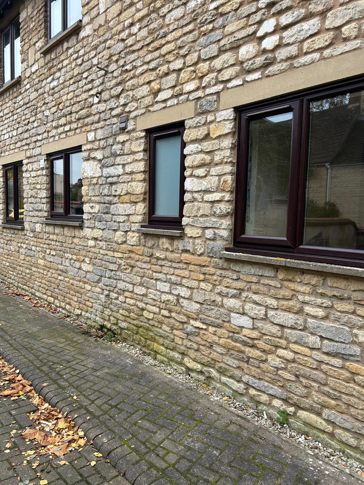 Rosewood woodgrain windows fitted into limestone openings on a period building in Stamford