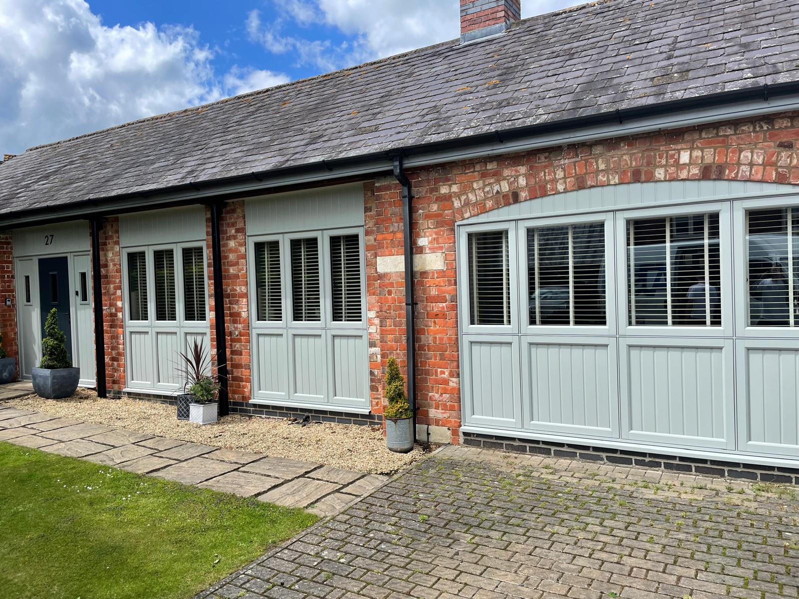 Arched window and sage green glazing on a brick barn conversion frontage in Rutland