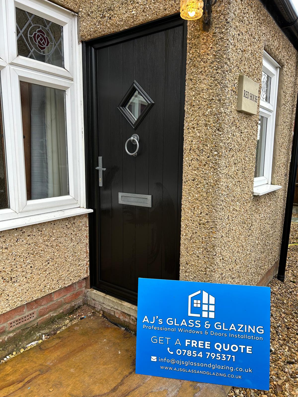 Black composite cottage front door with diamond light and ring knocker fitted at a Stamford property