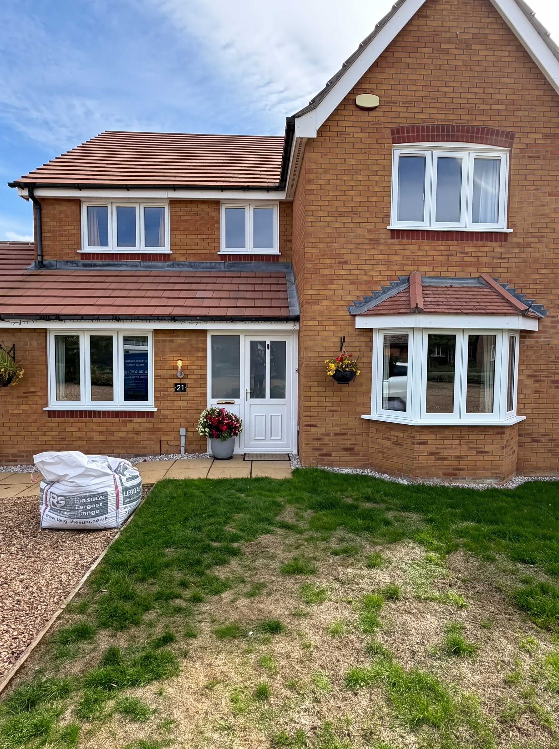 White flush UPVC replacement windows and new white front door on a brick house in Langtoft